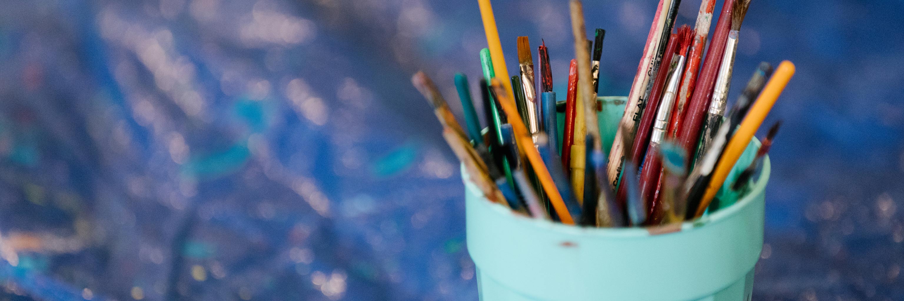 Close up of a cup full of paint brushes