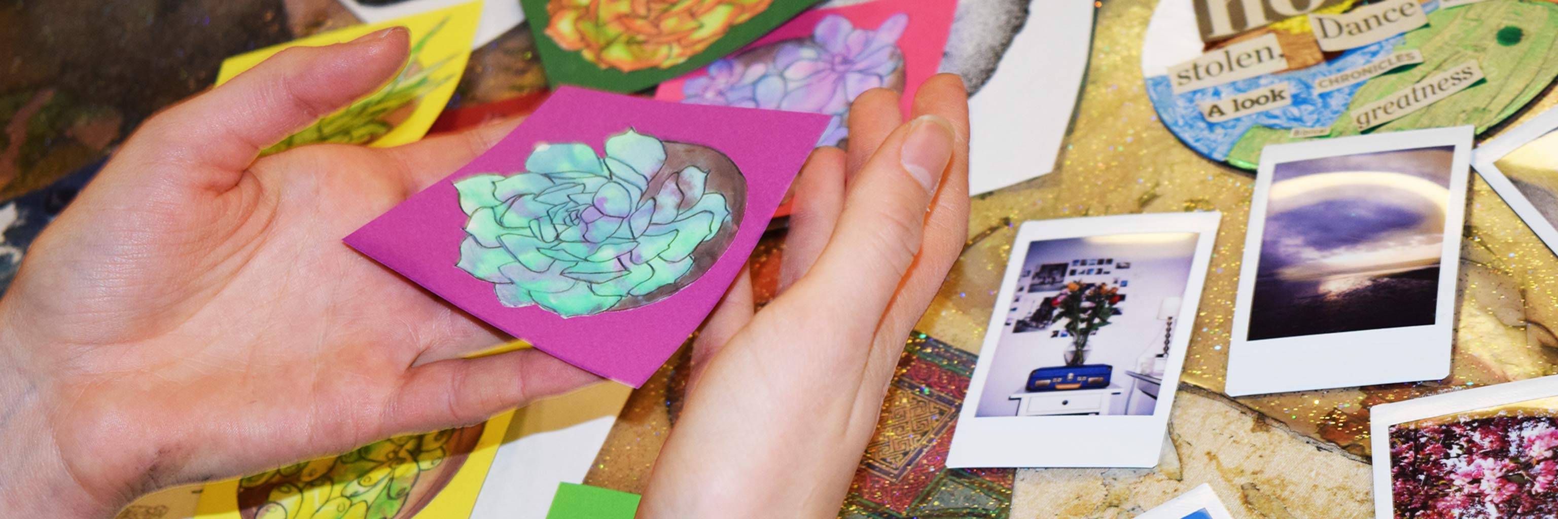 Close up of a pair of hands cradling a small painting of a flower