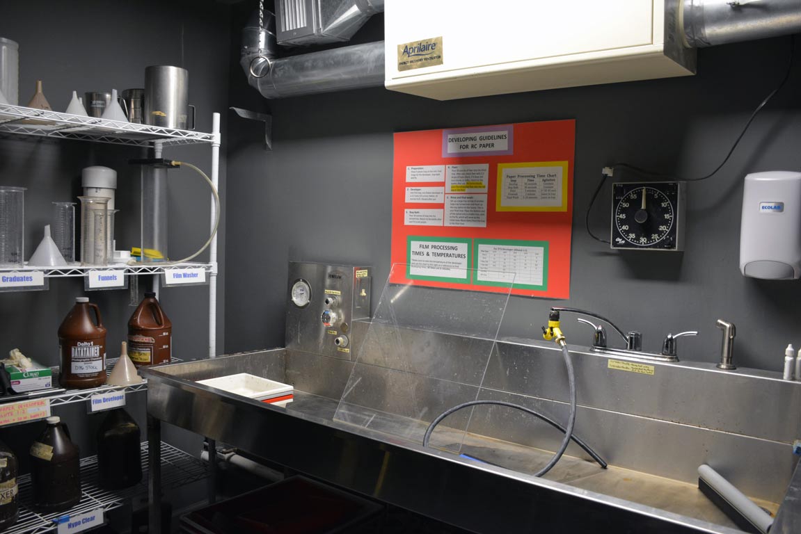 A large sink and shelf of supplies in the photography darkroom 